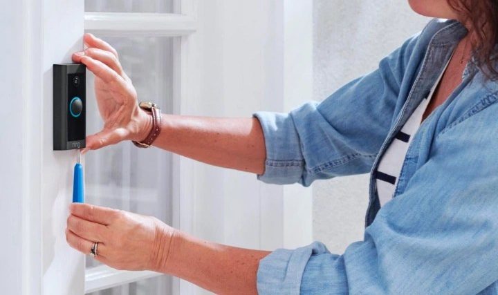 Person unmounting a Ring doorbell.