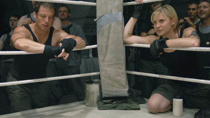 Lee Adama and Kara Thrace at ringside during a boxing match in the Battlestar Galactica episode Unfinished Business.