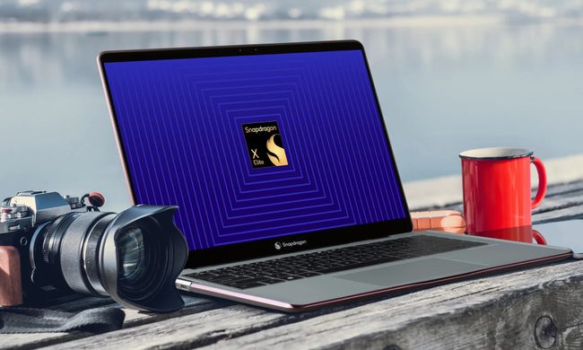 A laptop and a camera on a table with a Qualcomm logo on the screen.