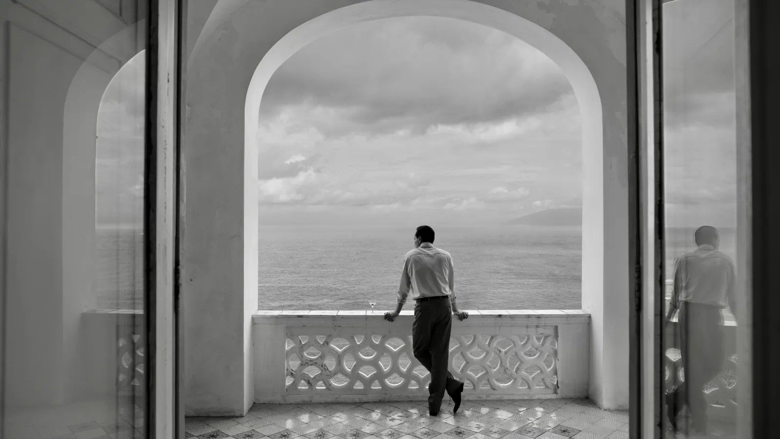Andrew Scott looks out at an extravagant ocean view in a black-and-white still from Ripley